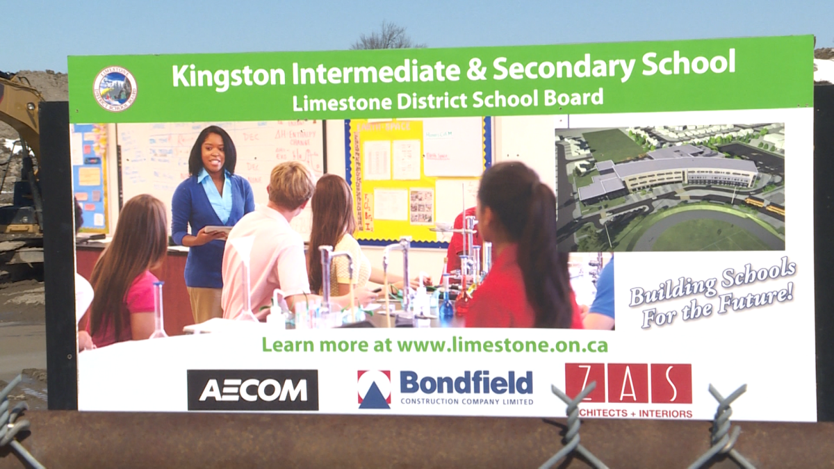 A sign advertising Kingston's new intermediate and secondary school near the construction site.