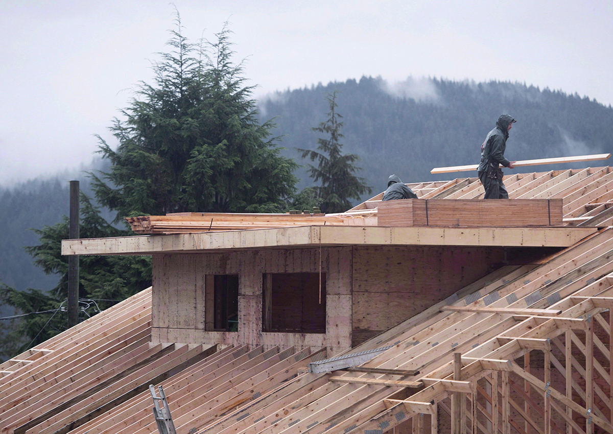 Builders work on a new home in North Vancouver on October 27, 2016. Canada Mortgage and Housing Corp. says the annual pace of housing starts picked up in February compared with January. 