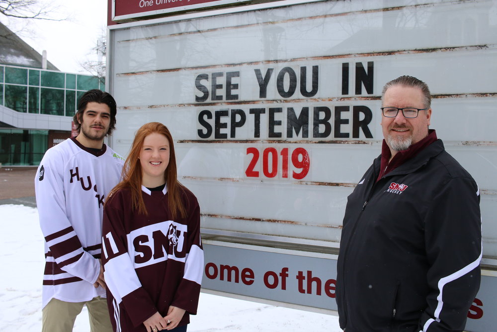 Saint Mary’s University students Anthony Repaci, Siobhan Birch and Athletics and Recreation Director Scott Gray pose for a photo.