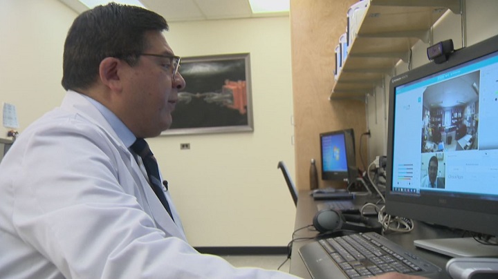 With the help of a robot, Dr. Ivar Mendez tours the nursing station at Pelican Narrows and talks to staff.