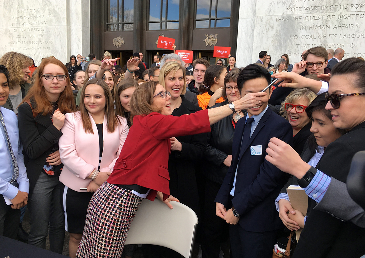 Oregon Gov. Kate Brown hands out one of the pens that she used to sign the first gun-control legislation signed into law in America since the Valentine’s Day massacre at a Florida high school, on the steps of the state Capitol in Salem, Ore., Monday, March 5, 2018. 
