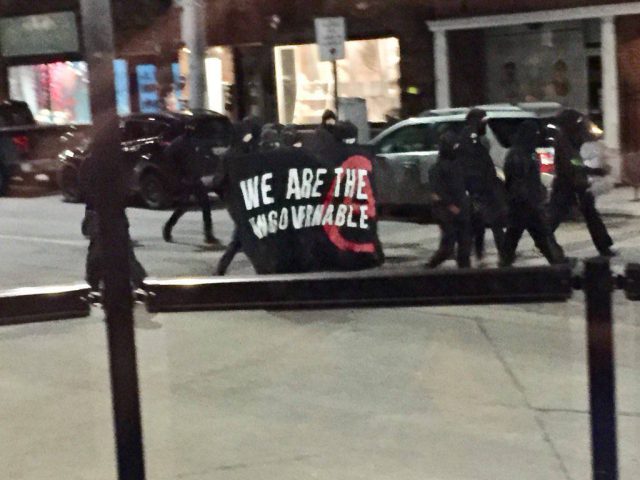 A group of about 30 masked people marched down Locke Street on Saturday night, smashing windows with rocks and damaging vehicles.