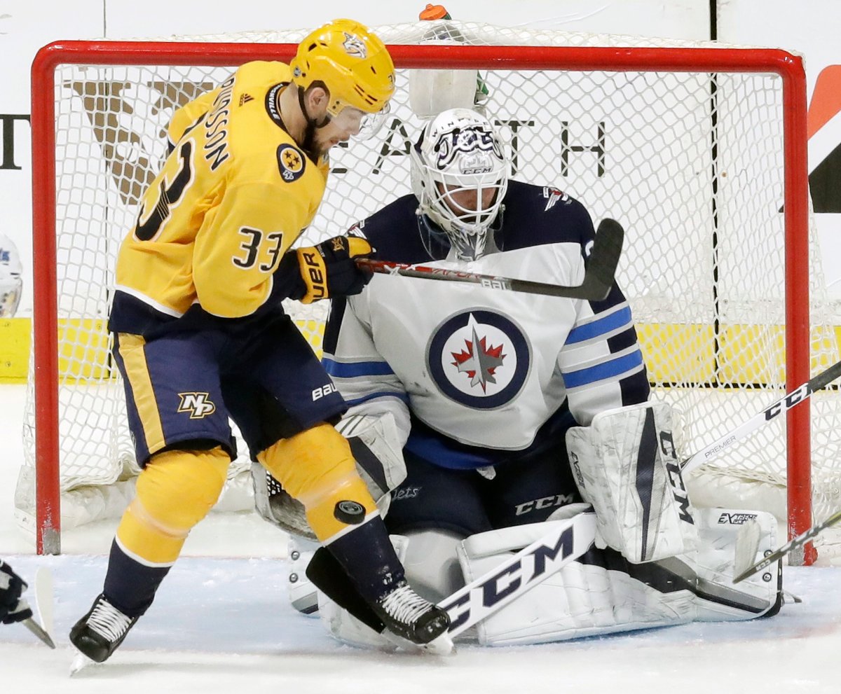 Nashville Predators left wing Viktor Arvidsson (33), of Sweden, tries to deflect the puck against Winnipeg Jets goalie Michael Hutchinson in the first period of an NHL hockey game Tuesday, March 13, 2018, in Nashville, Tenn. (AP Photo/Mark Humphrey).