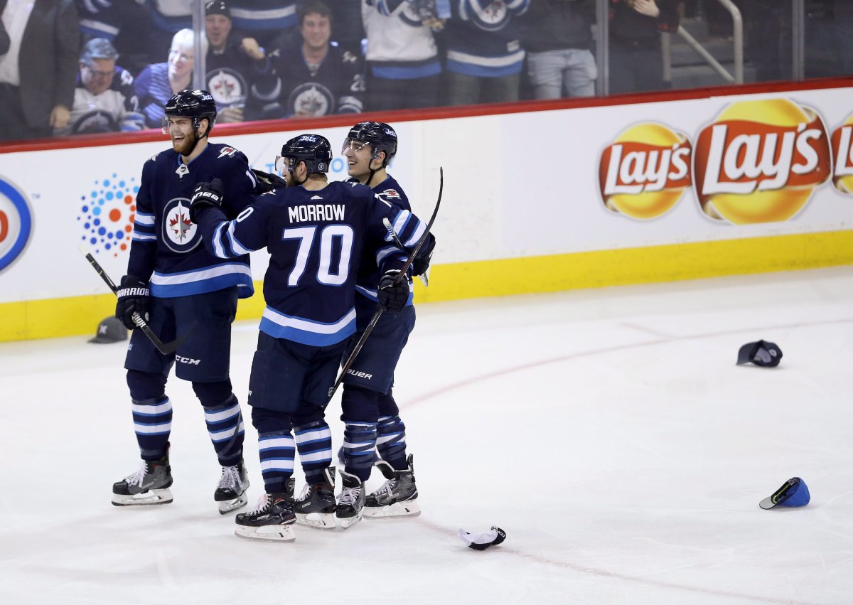 Winnipeg Jets' Adam Lowry (17), Joe Morrow (70) and Brandon Tanev (13) celebrate after Tanev scored his third goal against the Boston Bruins during third period NHL hockey action in Winnipeg, Tuesday, March 27, 2018. THE CANADIAN PRESS/Trevor Hagan.