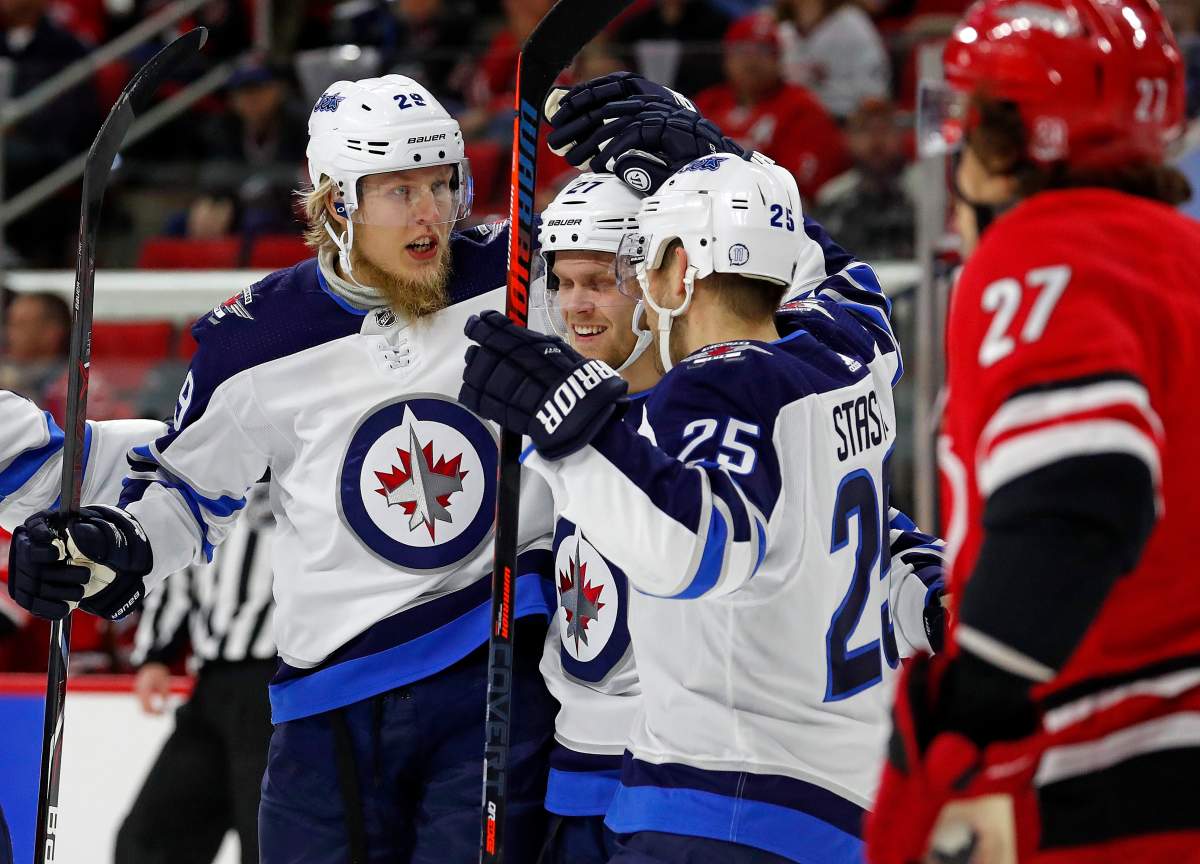 Winnipeg Jets' Patrik Laine (29) celebrates his goal with teammates Nikolaj Ehlers (27) and Paul Stastny (25) during the first period of an NHL hockey game against the Carolina Hurricanes, Sunday, March 4, 2018, in Raleigh, N.C. Laine had two goals in the 3-2 win. (AP Photo/Karl B DeBlaker).