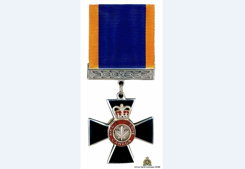 The medal is a blue cross with a silver maple leaf centre which is suspended by a blue ribbon with gold edges.