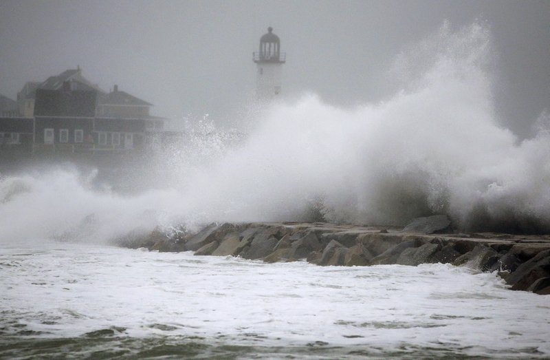FILE - Waves crash against a seawall near the Scituate Lighthouse, Friday, March 2, 2018, in Scituate, Mass.