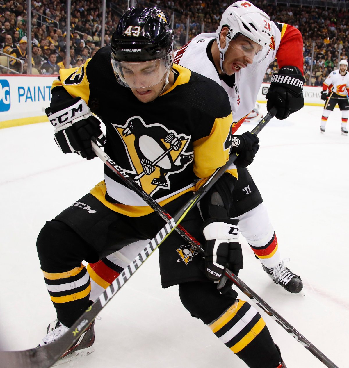 Calgary Flames' Travis Hamonic (24) battles Pittsburgh Penguins' Conor Sheary for the puck in the corner during the second period of an NHL hockey game in Pittsburgh, Monday, March 5, 2018. (AP Photo/Gene J. Puskar).