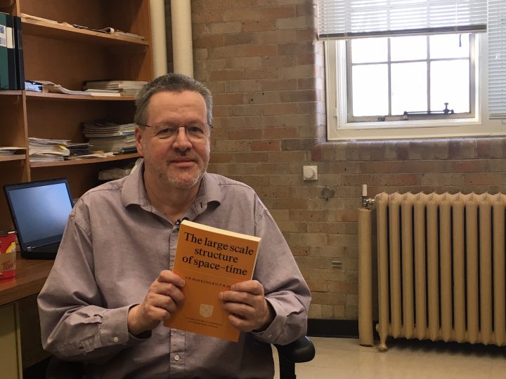 U of S physics and engineering professor Rainer Dick holds Stephen Hawking’s book, The Large Scale Structure of Space-Time.