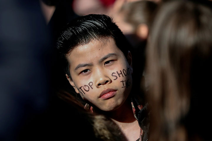 A student from wears a “Stop Shooting” message on his face during the National School Walkout in the Manhattan borough of New York City, March 14, 2018.