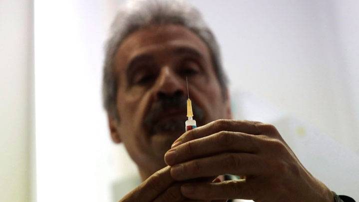 In this photo taken on Friday, Feb. 23, 2018, Dr. Roberto Ieraci checks a syringe before vaccinating a child in Rome. The nation is battling one of its worst epidemics of measles in recent years, reporting a six-fold increase in cases last year that accounted for a quarter of all the cases in Europe.