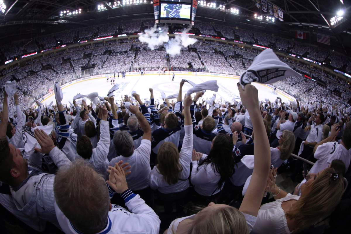 Winnipeg Jets fans celebrate a first period goal against the Anaheim Ducks during game three NHL playoff hockey action in Winnipeg on April 20, 2015.  THE CANADIAN PRESS/Trevor Hagan.