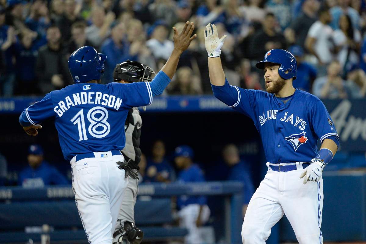 Toronto Blue Jays catcher Russell Martin (55) celebrates with teammate Curtis Granderson (18) after hitting a two-run home run during seventh inning American League baseball action in Toronto on Monday, April 2, 2018. 