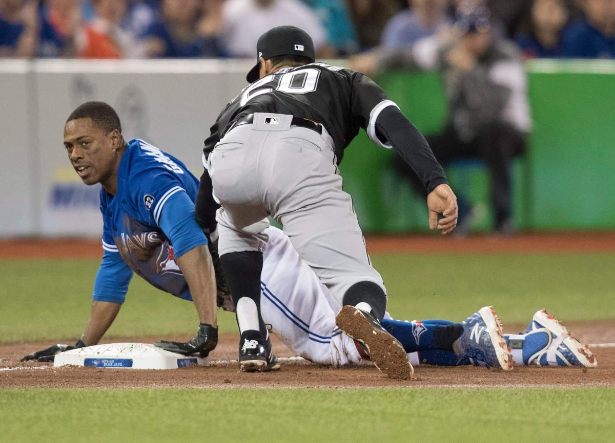 Toronto Blue Jays Curtis Granderson slides safely into third with a triple as Chicago White Sox third baseman Tyler Saladino tries to make a play in the fourth inning of their American League MLB baseball game in Toronto on Tuesday April 3, 2018. 