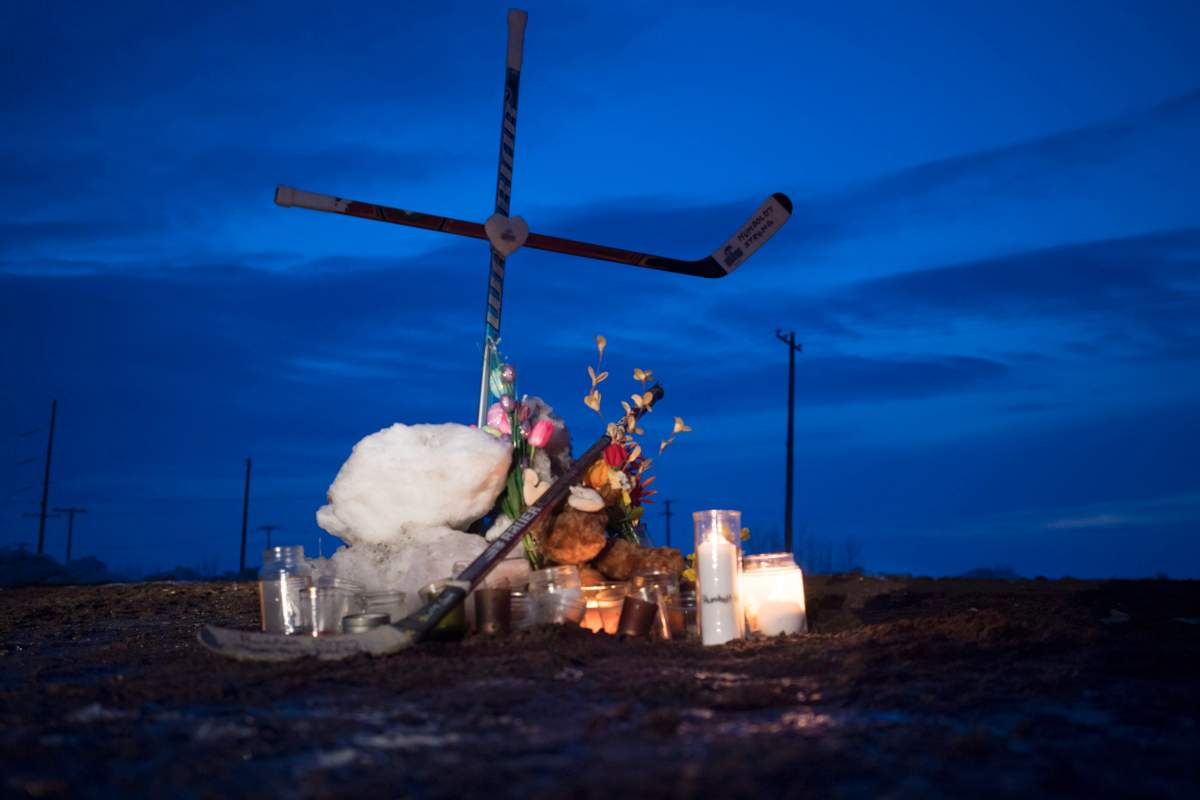 A cross made of hockey sticks is seen at a makeshift memorial at the intersection of a fatal bus crash near Tisdale, Sask., Monday, April, 9, 2018.