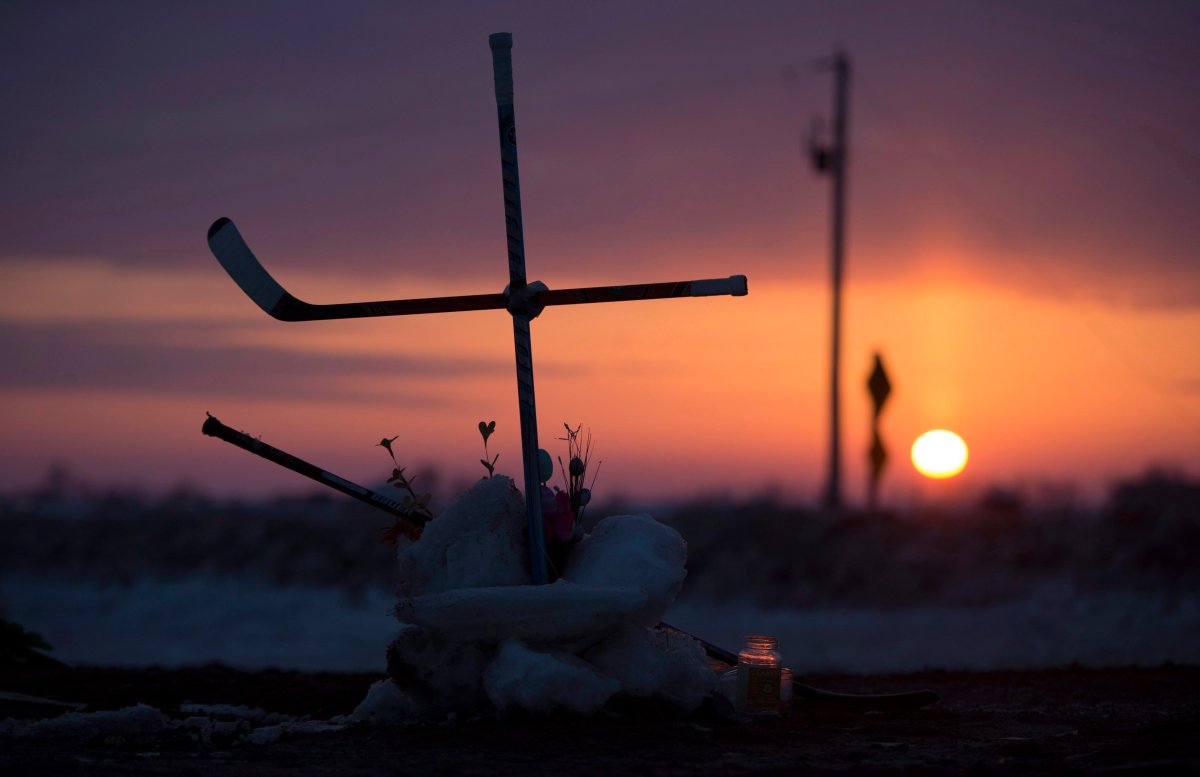 The sun rises across the Prairies as a cross made out of hockey sticks is seen at a makeshift memorial at the intersection of of a fatal bus crash near Tisdale, Sask., Tuesday, April, 10, 2018. A bus carrying the Humboldt Broncos hockey team crashed into a truck en route to Nipawin for a game Friday night, killing 15 and sending more than a dozen more to hospital.