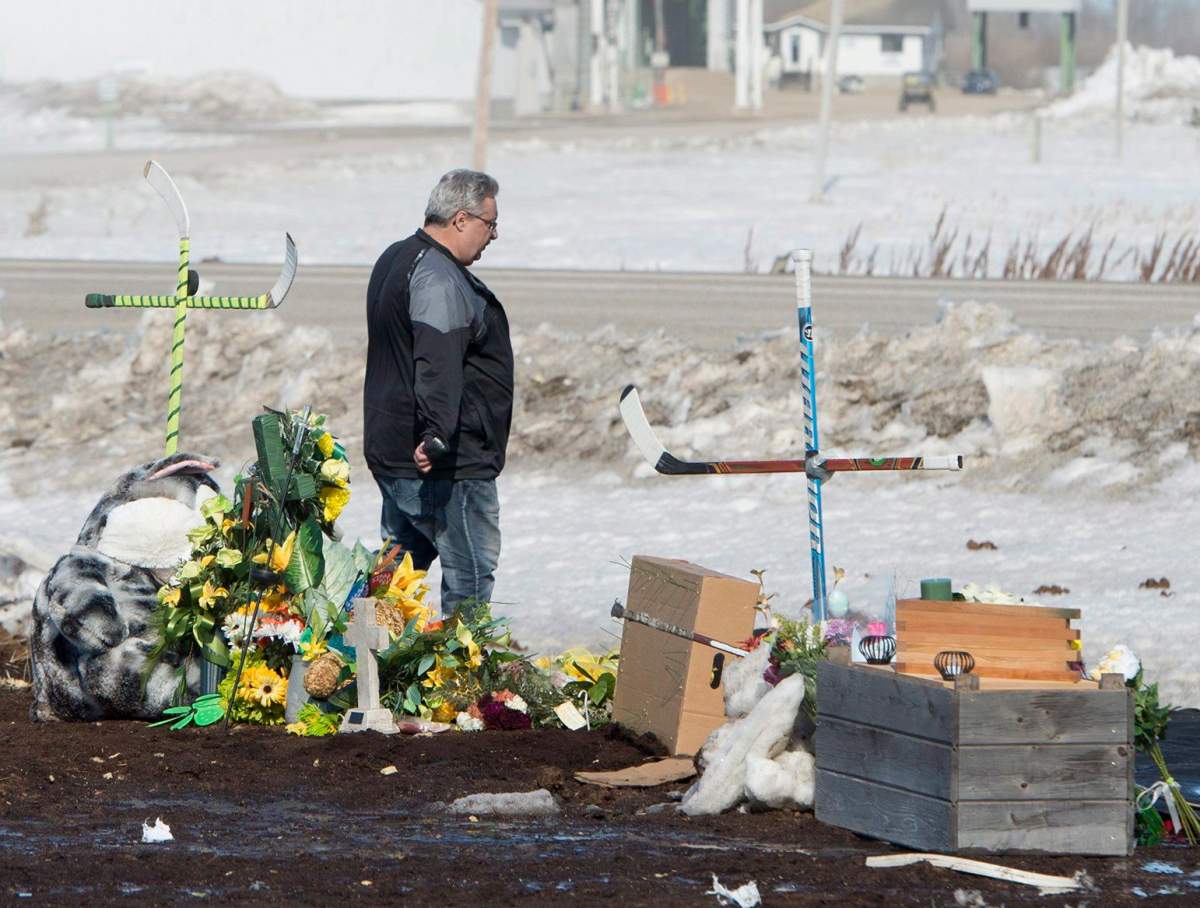 Myles Shumlanski looks around a makeshift memorial at the intersection of a fatal bus crash near Tisdale, Sask., Tuesday, April, 10, 2018.