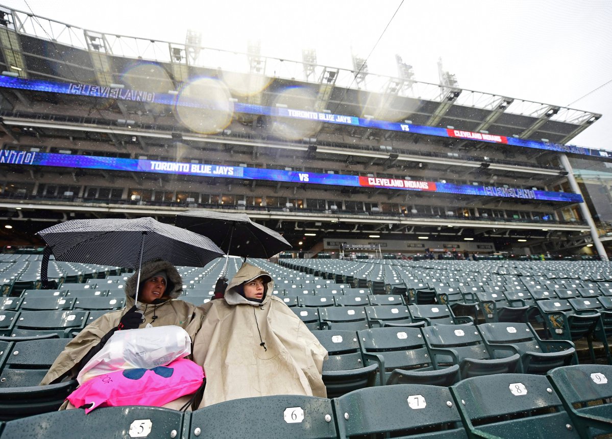 Annette and Kaden Decker sit as they wait out a rain delay in a baseball game between the Cleveland Indians and the Toronto Blue Jays, Saturday, April 14, 2018, in Cleveland. 