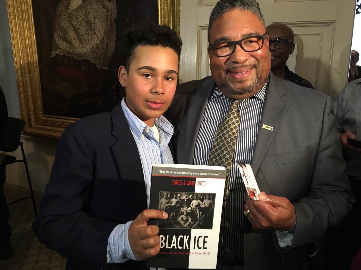 12-year-old Mark Connors, left, and African Nova Scotian Affairs Minister Tony Ince pose for a photo at the Nova Scotia Legislature in Halifax on Tuesday, April 17, 2018. 