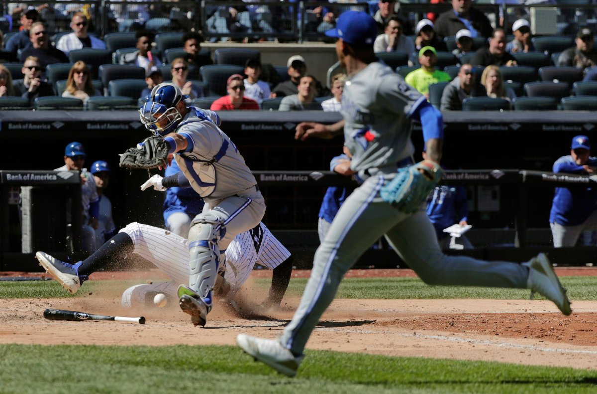 Toronto Blue Jays catcher Luke Maile drops the throw from pitcher Marcus Stroman, right, as New York Yankees' Aaron Judge slides safely into home plate on a bases-loaded infield grounder by Aaron Hicks during the sixth inning of a baseball game, Saturday, April 21, 2018, in New York. Judge was safe on the play.