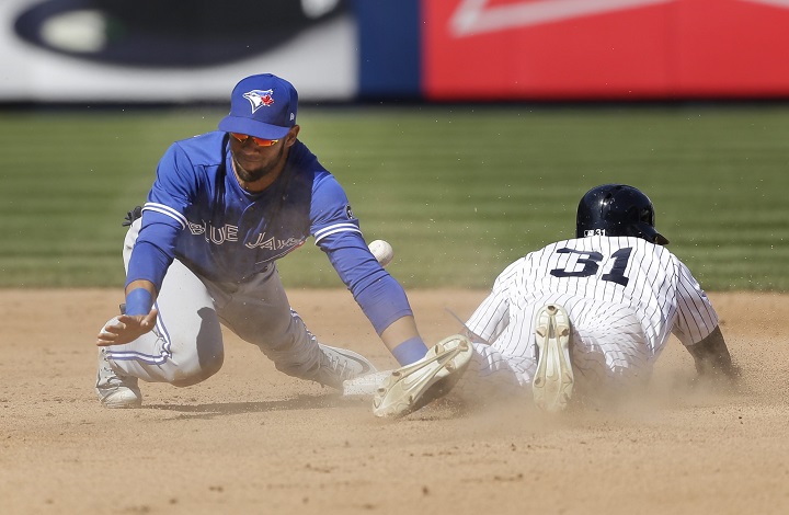 New York Yankees' Aaron Hicks, right, steals second base while Toronto Blue Jays shortstop Lourdes Gurriel tries to field a bad throw from catcher Russell Martin during the seventh inning of a baseball game at Yankee Stadium, Sunday, April 22, 2018, in New York. Gurriel count not control the ball and Hicks advanced to third base. 