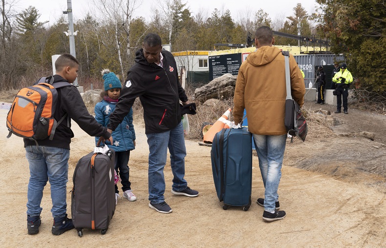 A family, claiming to be from Colombia, gets set to cross the border into Canada from the United States as asylum seekers on Wednesday, April 18, 2018 near Champlain, NY. 