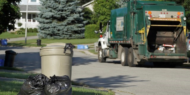 A trio of garbage containers sit on the curb of a London residence.