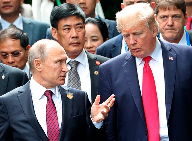 U.S. President Donald Trump, right, and Russia President Vladimir Putin talk during the family photo session at the APEC Summit in Danang. 