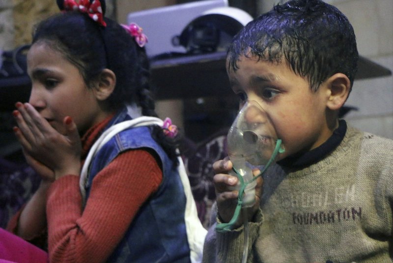 This image released early Sunday, April 8, 2018 by the Syrian Civil Defense White Helmets, shows a child receiving oxygen through respirators following an alleged poison gas attack in the rebel-held town of Douma, near Damascus, Syria.