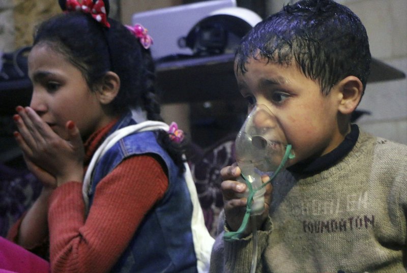 This image released early Sunday, April 8, 2018 by the Syrian Civil Defense White Helmets, shows a child receiving oxygen through respirators following an alleged poison gas attack in the rebel-held town of Douma, near Damascus, Syria. 