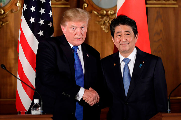 In this Nov. 6, 2017 file photo, U.S. President Donald Trump shakes hands with Japanese Prime Minister Shinzo Abe during a joint news conference at the Akasaka Palace, in Tokyo.  