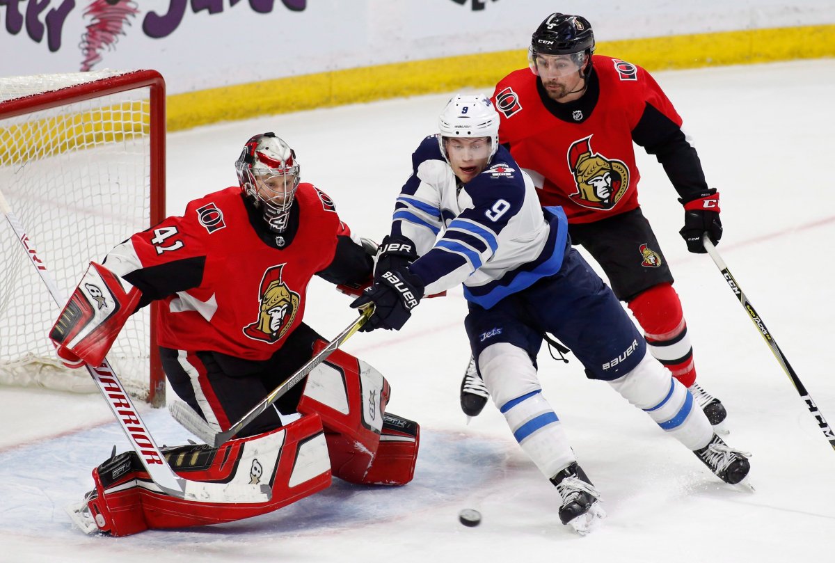 Winnipeg Jets Andrew Copp (9) tries to score on Ottawa Senators goaltender Craig Anderson (41) while being chased by defenceman Cody Ceci (5) at the Canadian Tire Centre in Ottawa.