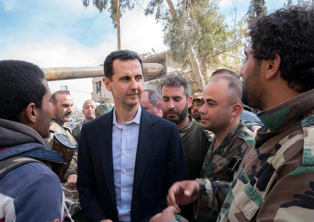 Syrian President Bashar al-Assad meets with Syrian army soldiers in eastern Ghouta, Syria, March 18, 2018. Syrian President Bashar al-Assad, his brother and two army generals are facing arrest warrants for alleged involvement in war crimes and crimes against humanity, due to a 2013 chemical attack on rebel-held Damascus suburbs, lawyers for Syrian victims said.