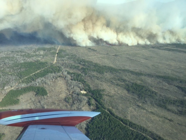 The view from a water bomber flying over a fire near Badger, Man.