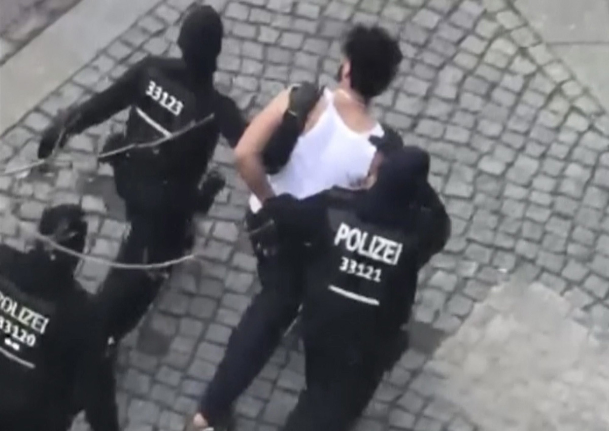 A suspect is lead away by police officers after he was arrested in Berlin, Germany, Sunday, April 8, 2018. 