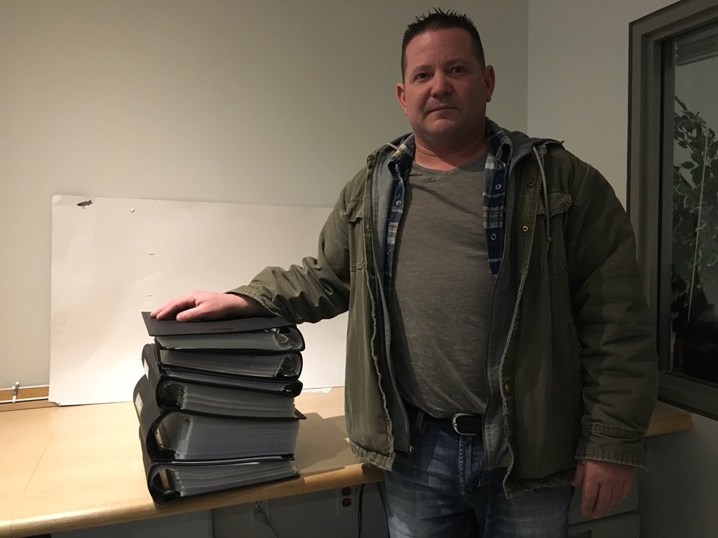 Bill Leetjes stands with the binders full of information he's documented about his allegations of harassment and discrimination at the London Transit Commission.