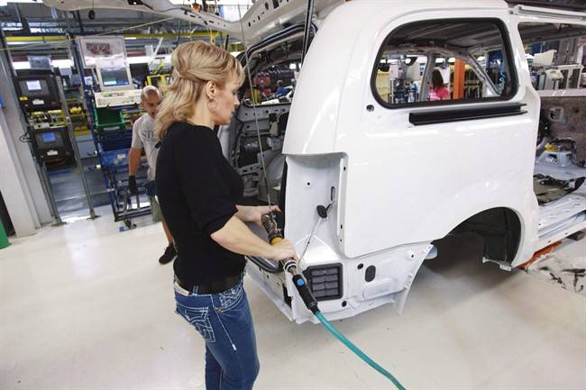 A worker on the production line at Chrysler's assembly plant in Windsor, Ontario, works on a minivan on Tuesday, January 18, 2011.
