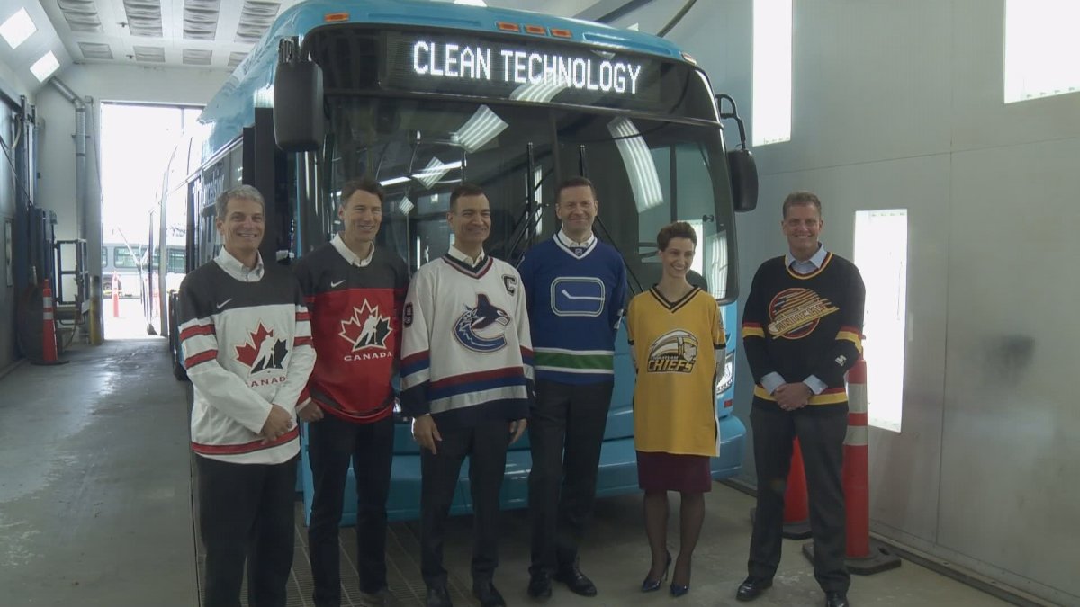 Vancouver Mayor Gregor Robertson, TransLink CEO, MP Joe Peschisolido  and others stand in front of an electric bus on April 12, 2018.