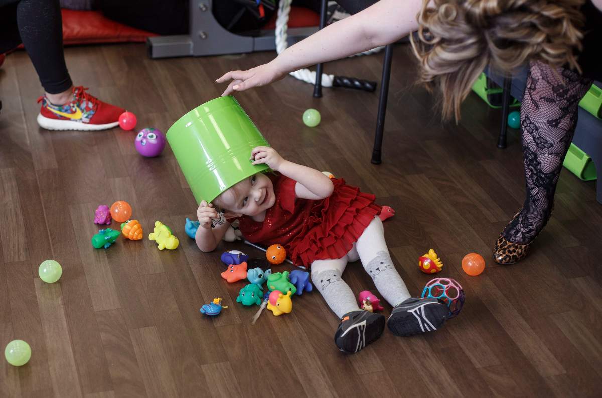 Evelyn Moore plays hide and seek with her mom Kim Moore at the ReYu Paralysis Recovery Centre in Edmonton Alta, on Wednesday April 4, 2018.