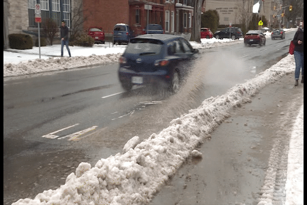 Tory Pearson gets sprayed by passing cars. Puddles are pooling all around Kingston as more rain falls over the Limestone City.