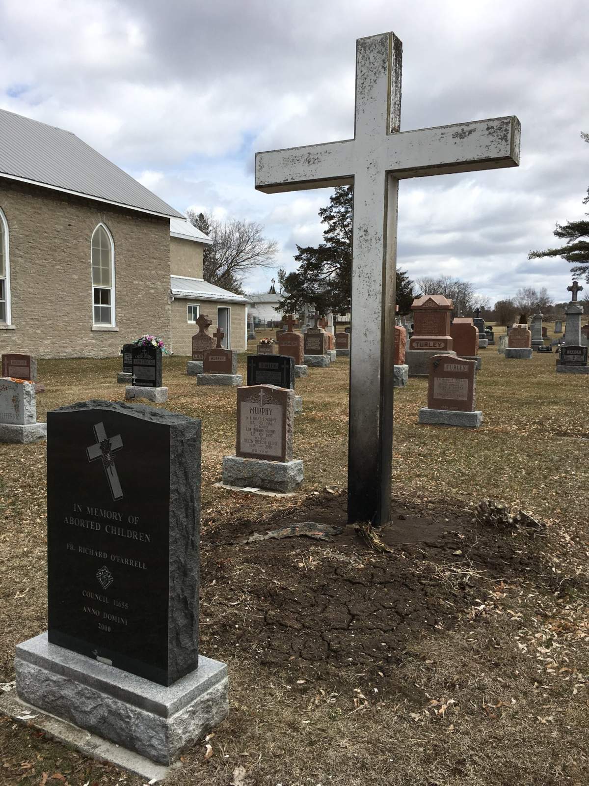 One person is charged after a concrete cross was set on fire in a Frankford cemetery.