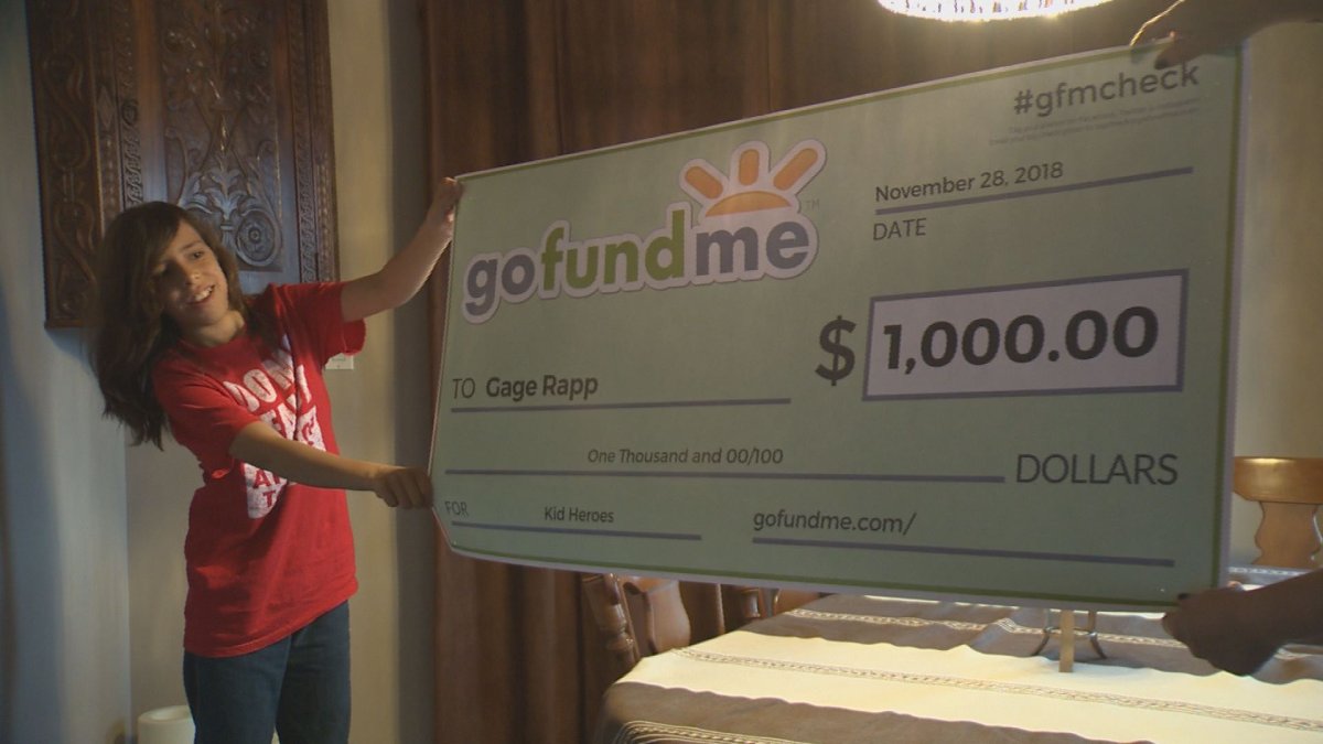 Gage Archer holds a large representation of the $1,000 cheque from GoFundMe. 