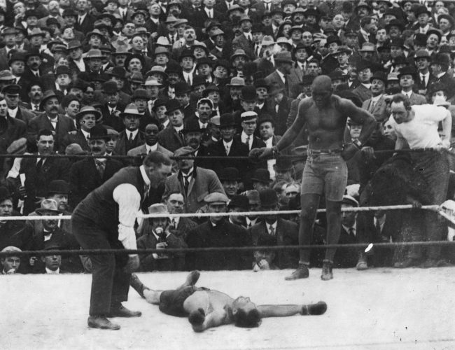 Jack Johnson looks on as opponent Stan Ketchel is counted out on Oct. 16, 1909.