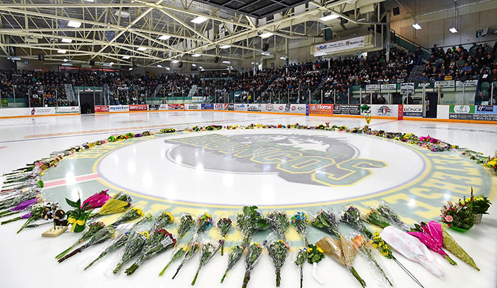 Flowers lie at centre ice as people gather for a vigil at the Elgar Petersen Arena, home of the Humboldt Broncos, to honour the victims of a fatal bus accident, April 8, 2018.
