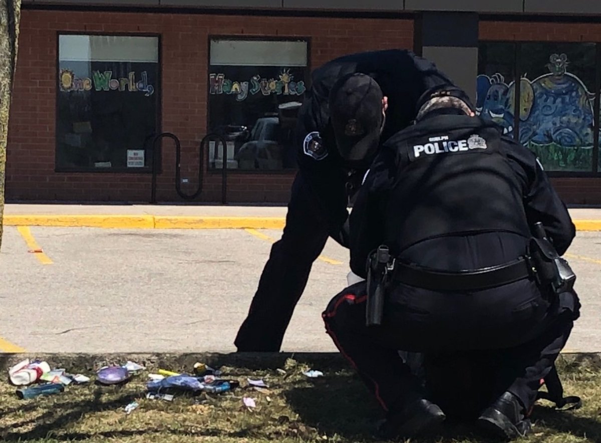 Guelph police officers collect items from a bag following a suspicious package investigation near Stone Road Mall on Thursday afternoon.
