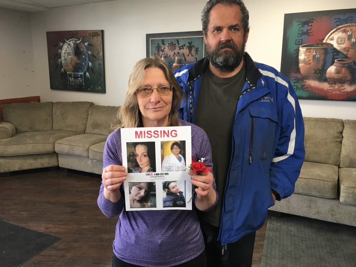 Nicole Bell’s parents hold a missing person poster displaying their daughter’s photo.