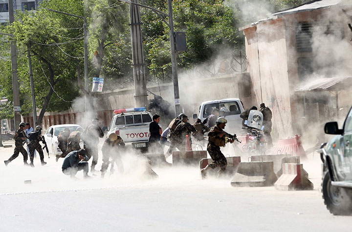 Security forces run from the site of a suicide attack in Kabul, Afghanistan, Monday, April 30, 2018.