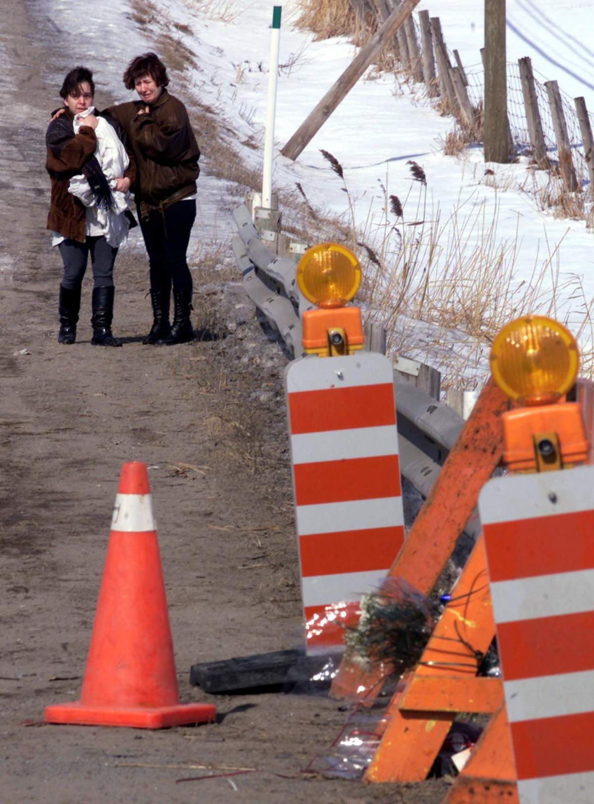 Two unidentified women hug as they visit the site where two minivans collided, one carrying 10 children from a daycare centre on Friday, March 17, 2000 in St-Jean-Baptiste de Nicolet, Que.