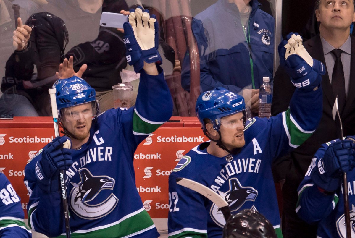 Vancouver Canucks Henrik (33) and Daniel Sedin (22) wave to the crowd during a standing ovation during third-period NHL action against the Las Vegas Knights at Rogers Arena in Vancouver on April 3, 2018.