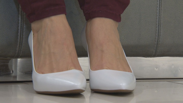 a cantora Stacey Nattrass dos Jets a experimentar sapatos brancos.